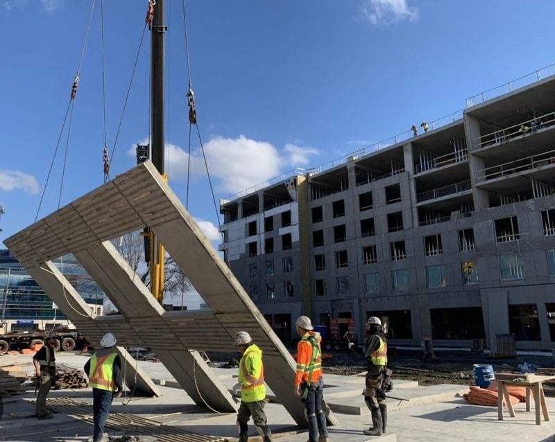 A group of construction workers are standing in front of a building under construction.