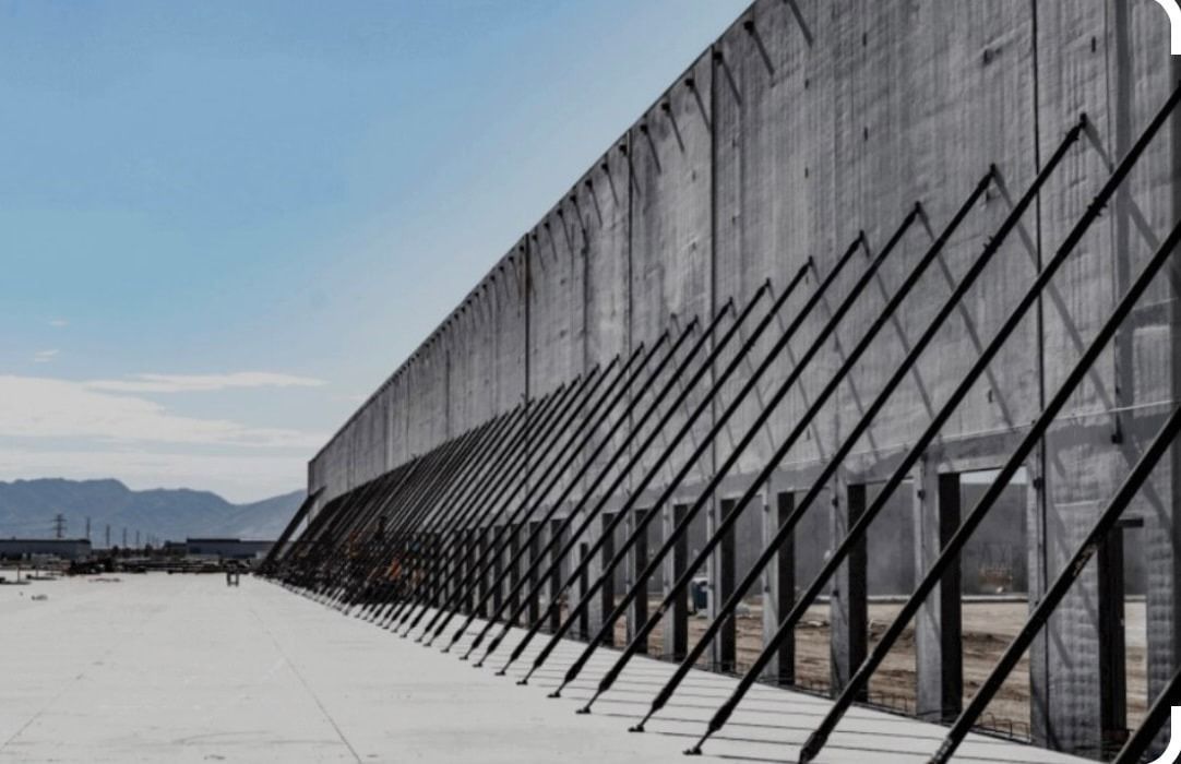 A large concrete wall with a lot of metal bars on it.
