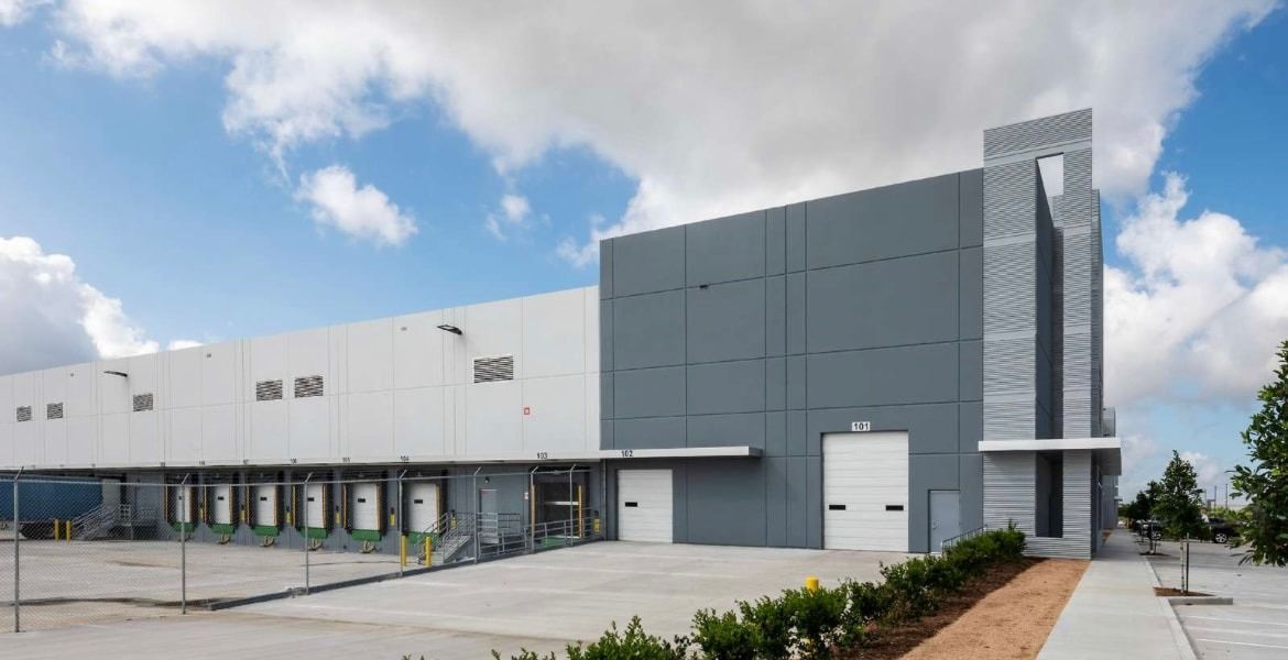 A large warehouse building with a lot of doors and a staircase.