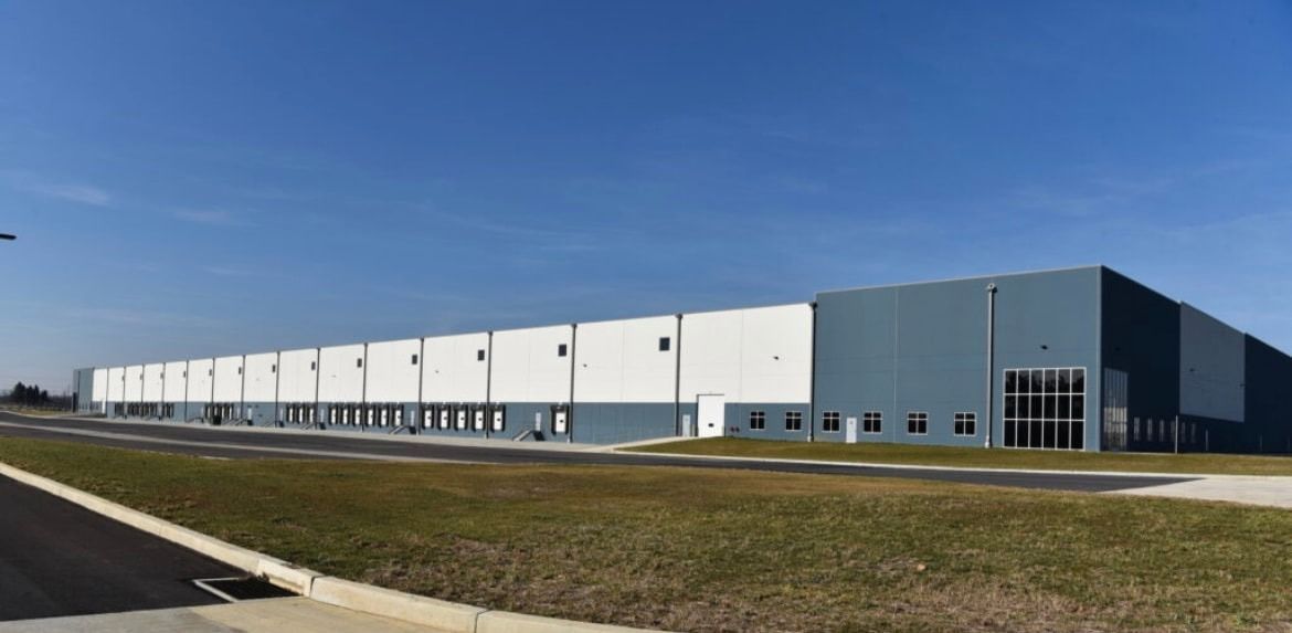 A large warehouse building with a blue sky in the background.
