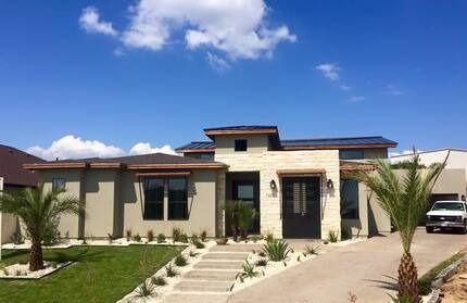 A large house with a lot of windows and a palm tree in front of it.