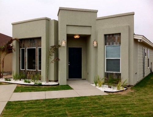 A house with a lush green lawn in front of it