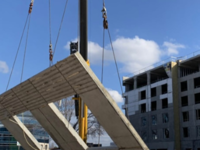 A large piece of wood is being lifted by a crane