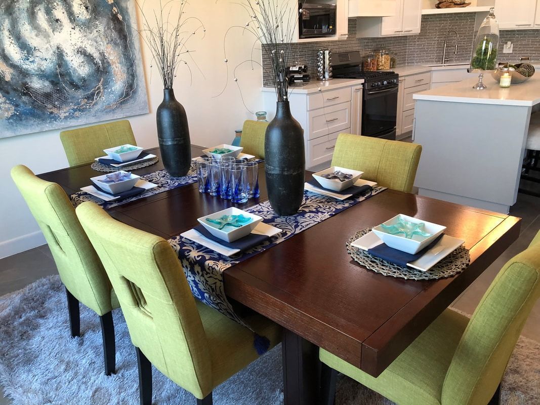 A dining room table with yellow chairs and plates on it