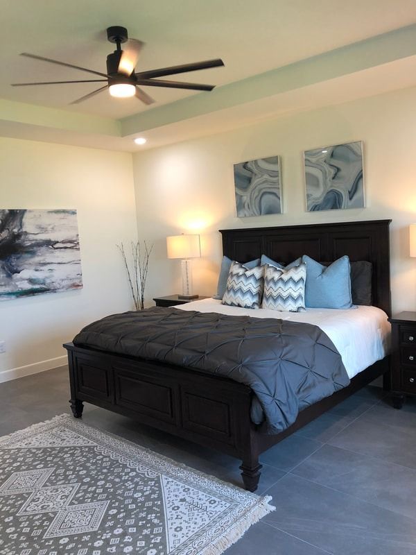 A bedroom with a large bed and a ceiling fan