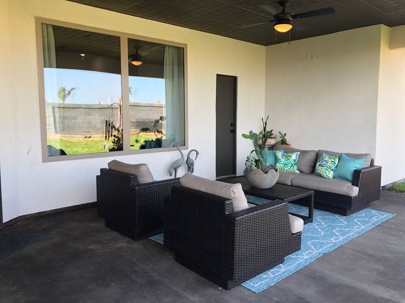 A patio with a couch , chairs , and a table.
