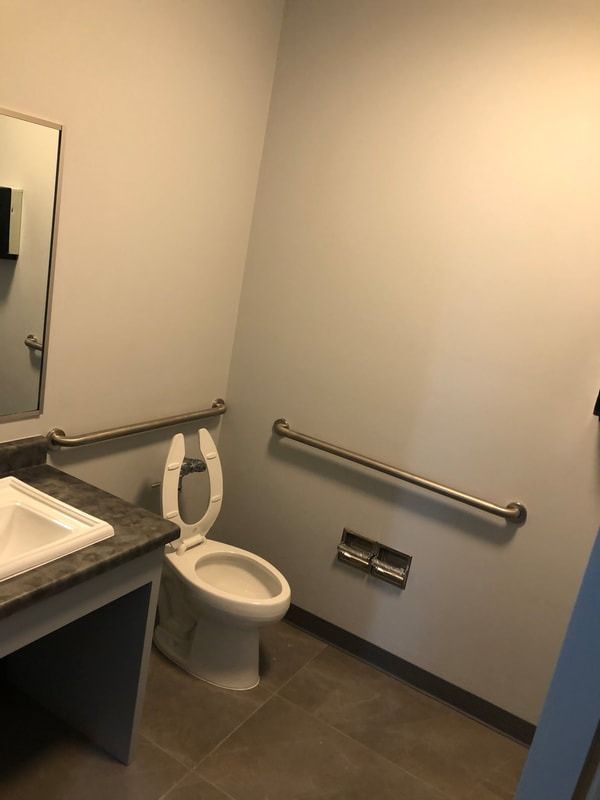 A bathroom with a toilet , sink and mirror