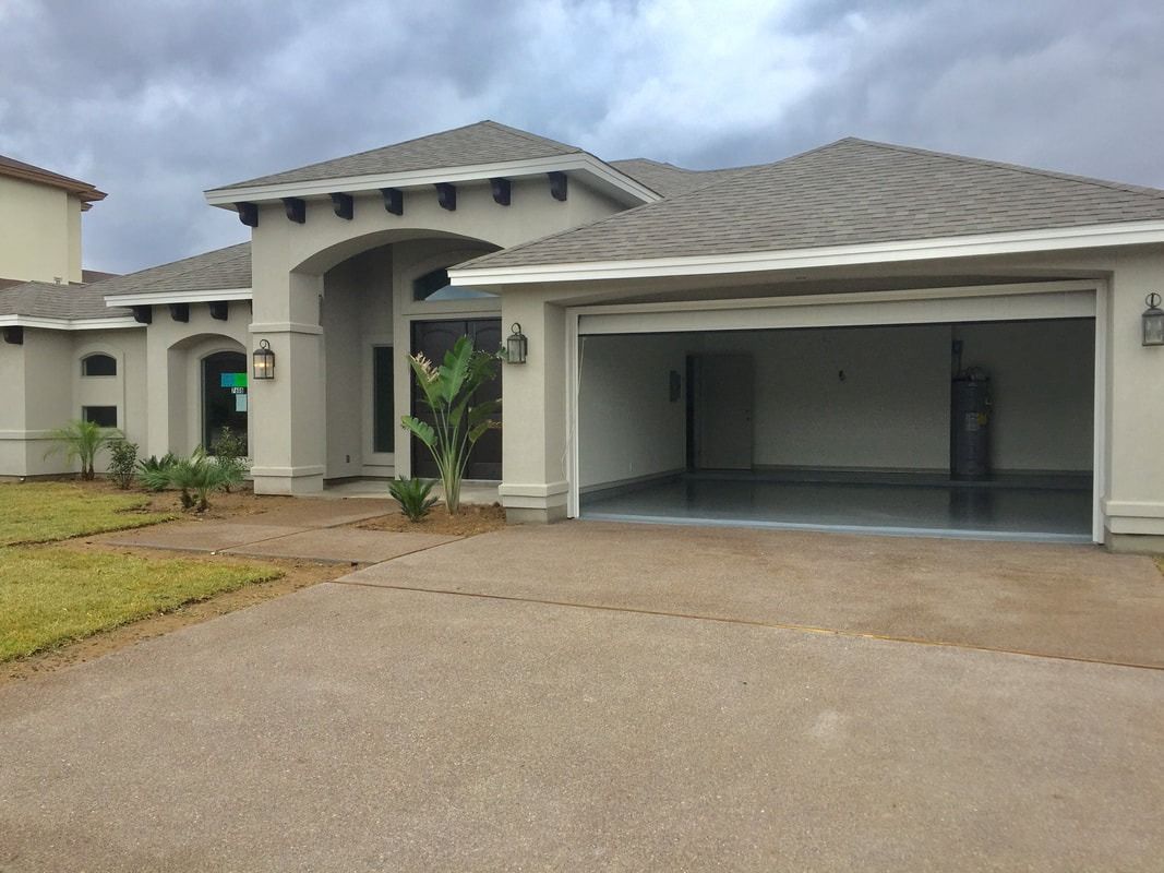 A large white house with a garage and a driveway.