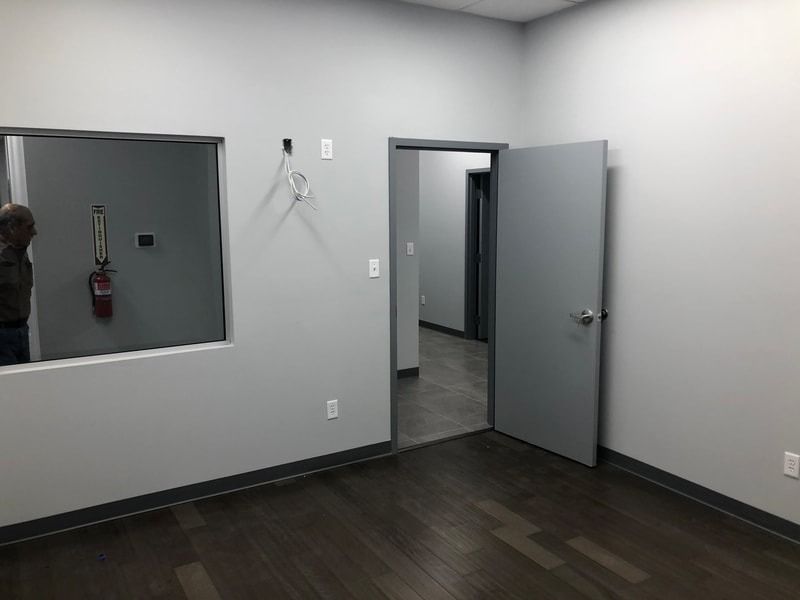 An empty room with a door and a window.