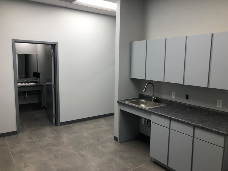 A kitchen with white cabinets and a sink