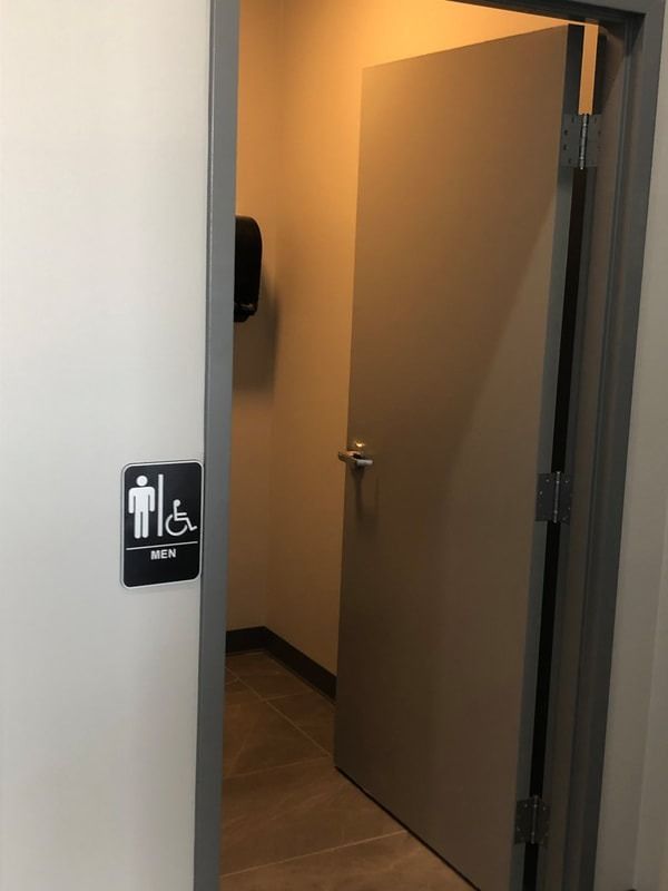 A bathroom with a handicapped sign on the wall