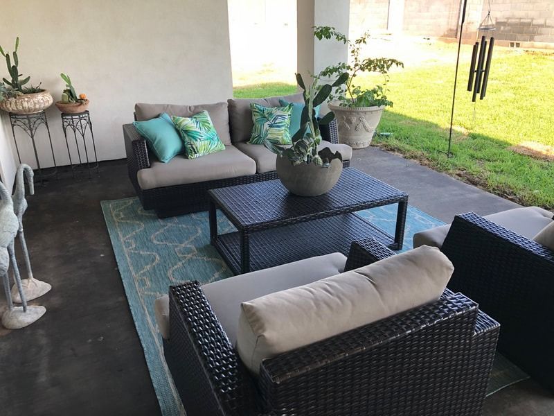 A patio with a couch and chairs and a coffee table