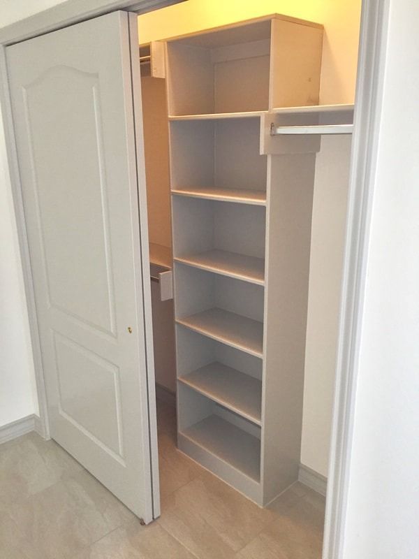 A closet with shelves and a sliding door