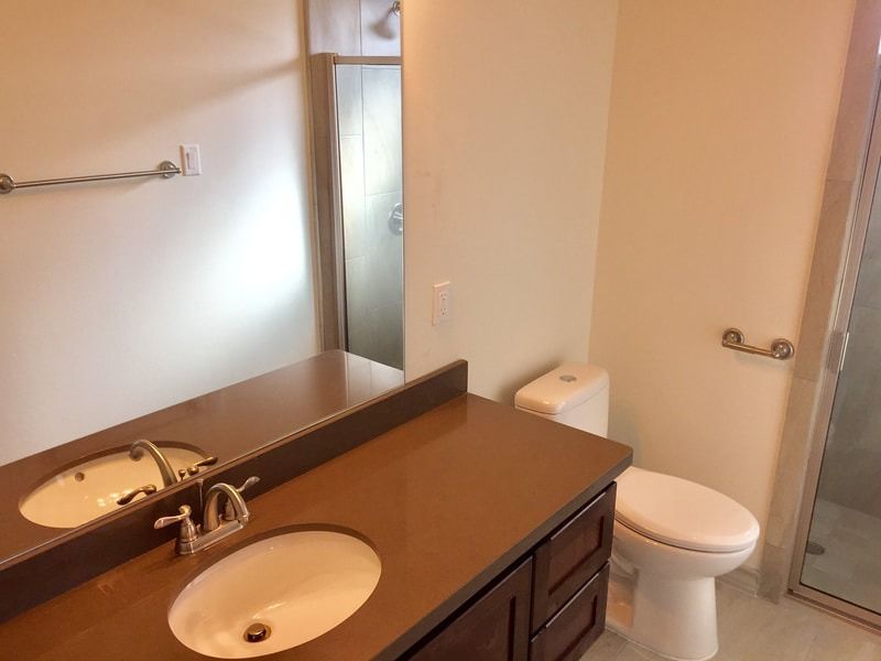 A bathroom with a toilet a sink and a mirror