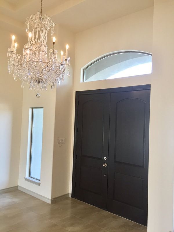 A chandelier is hanging from the ceiling above a doorway