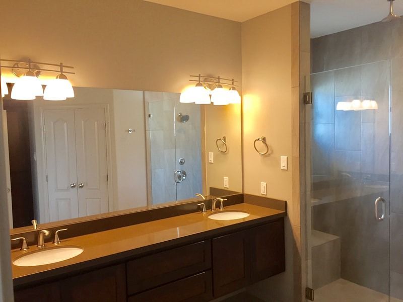 A bathroom with two sinks and a large mirror