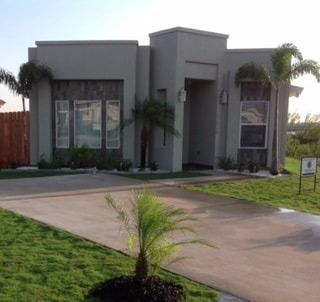 A house with a lot of windows and palm trees in front of it