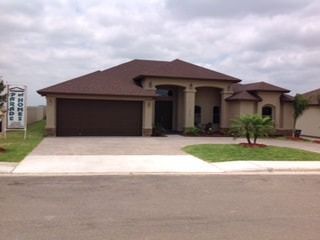 A large house with a brown garage door is for sale