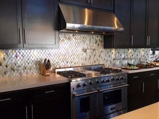 A kitchen with stainless steel appliances and black cabinets