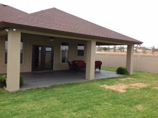 A house with a covered patio in the backyard.