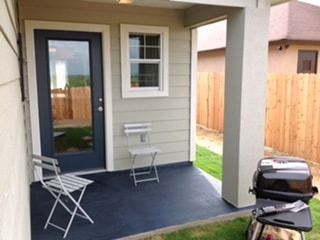 A porch with a chair and a grill on it