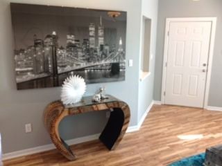 A living room with a wooden table and a painting on the wall.