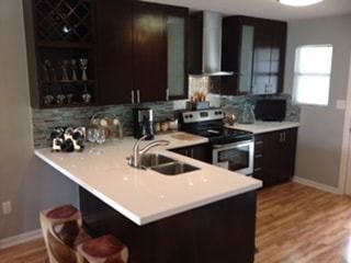 A kitchen with a stove , sink , and stools.