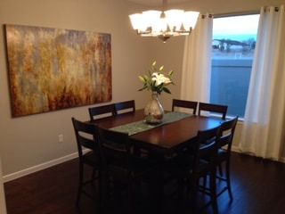 A dining room table with a vase of flowers on it