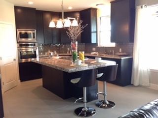 A kitchen with black cabinets and granite counter tops