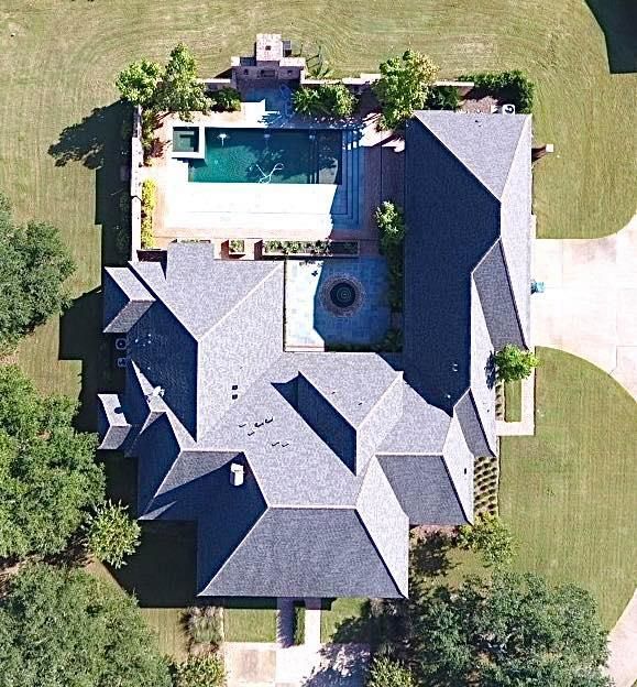 An aerial view of a large house with a pool
