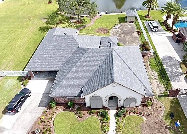 An aerial view of a large house with a car parked in front of it.