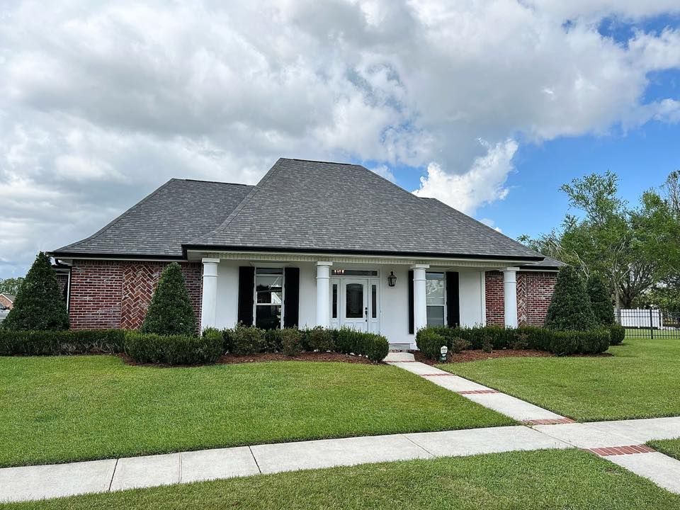 A large brick house with a gray roof and black shutters