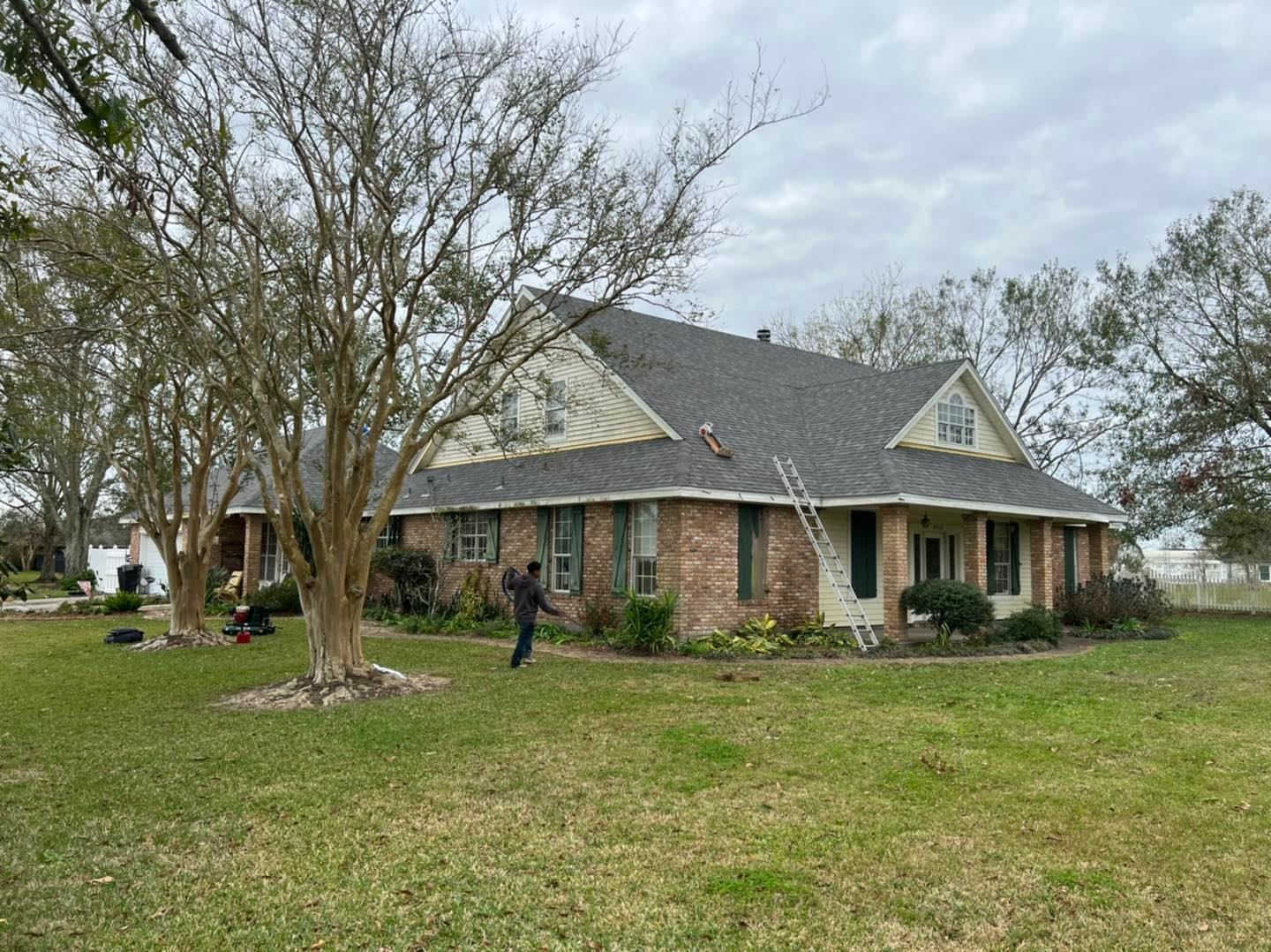 A large brick house with a large lawn in front of it.