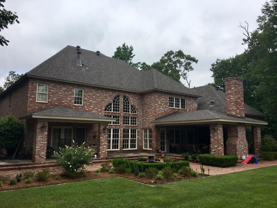 A large brick house with a large lawn in front of it