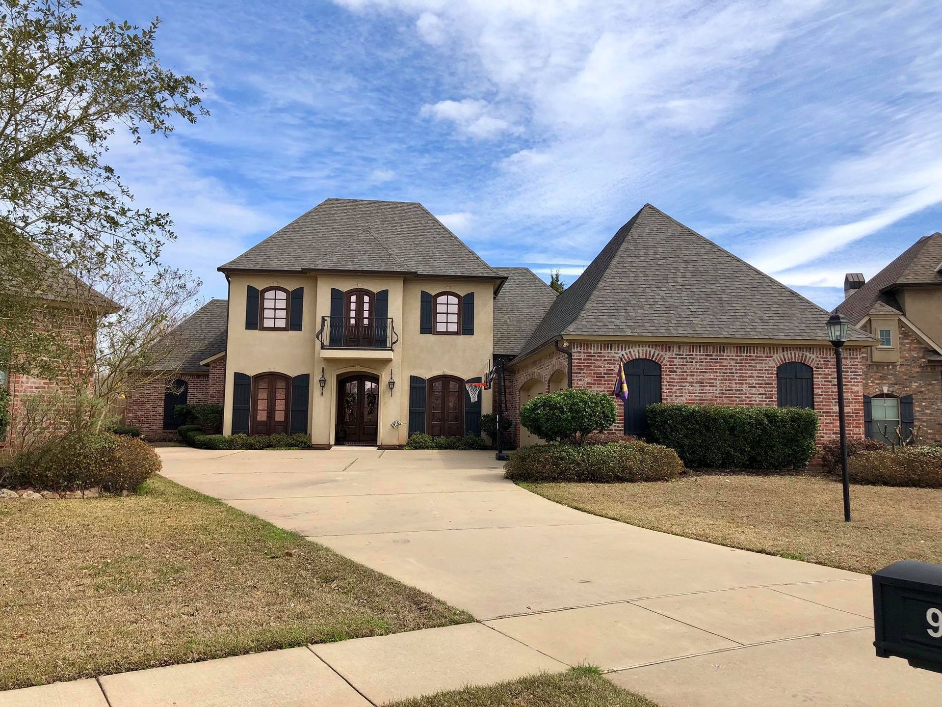 A large brick house with a driveway leading to it