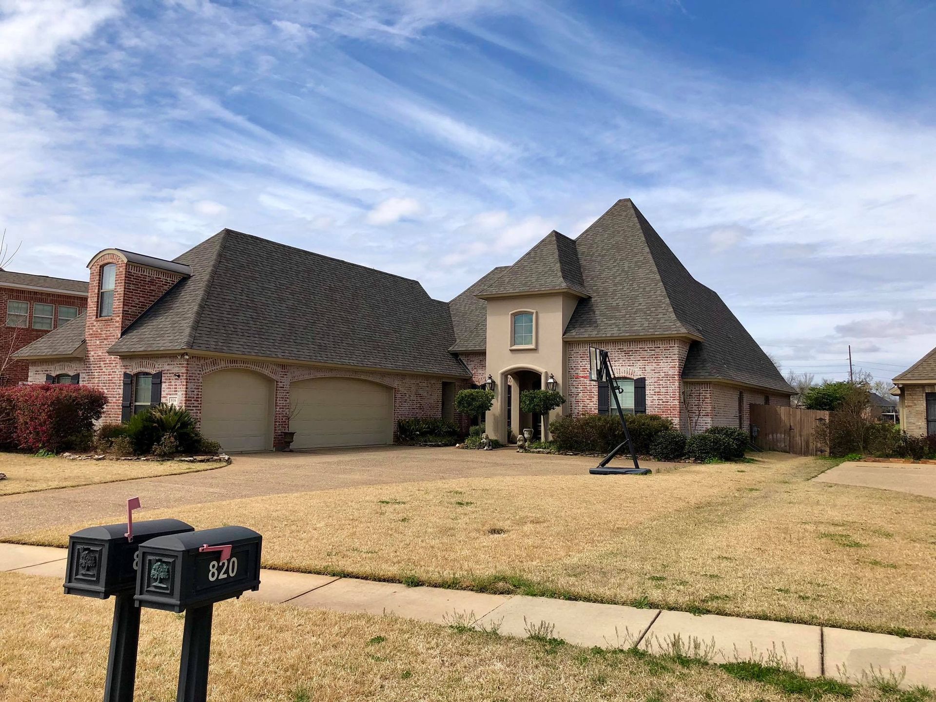 A large brick house with a mailbox in front of it.