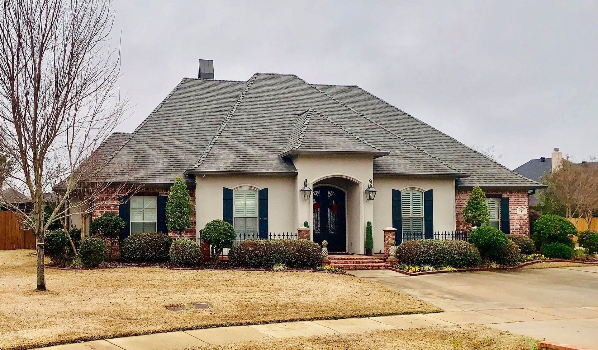 A large house with a gray roof and blue shutters