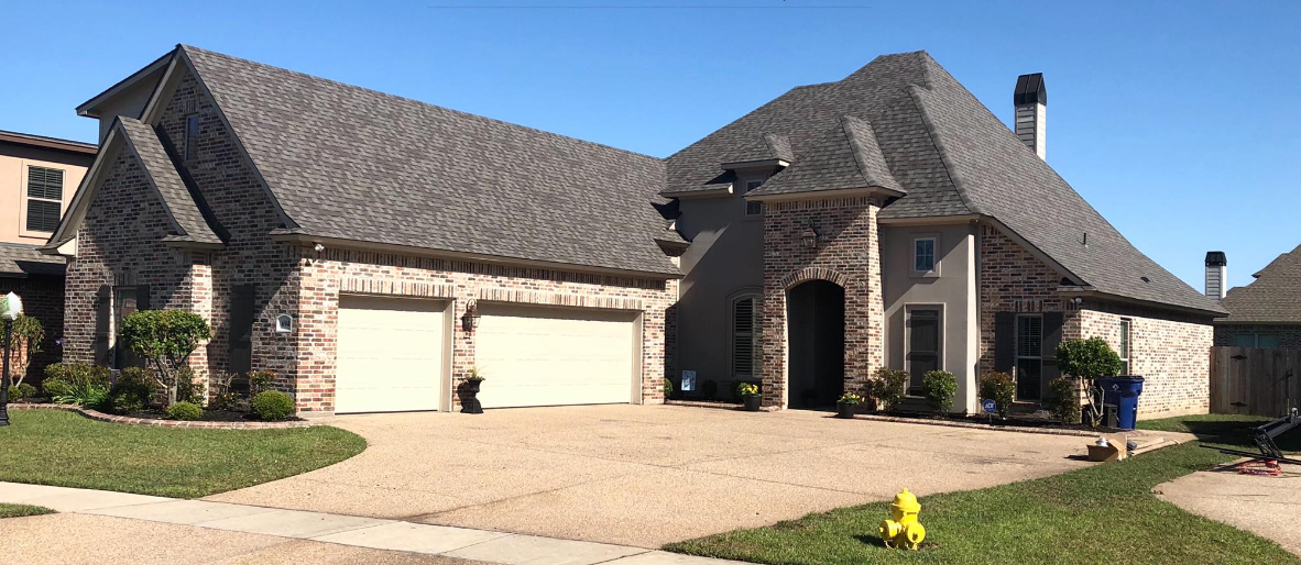 A large brick house with a fire hydrant in front of it.
