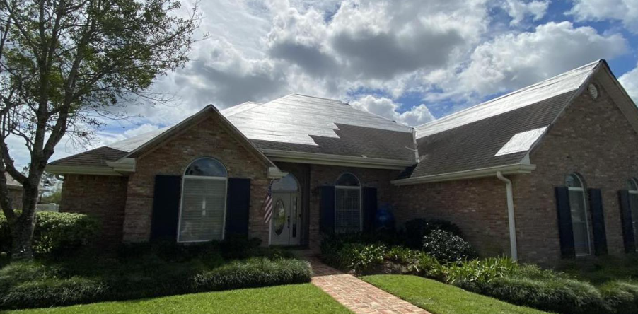 A large brick house with a roof that is covered in solar panels.