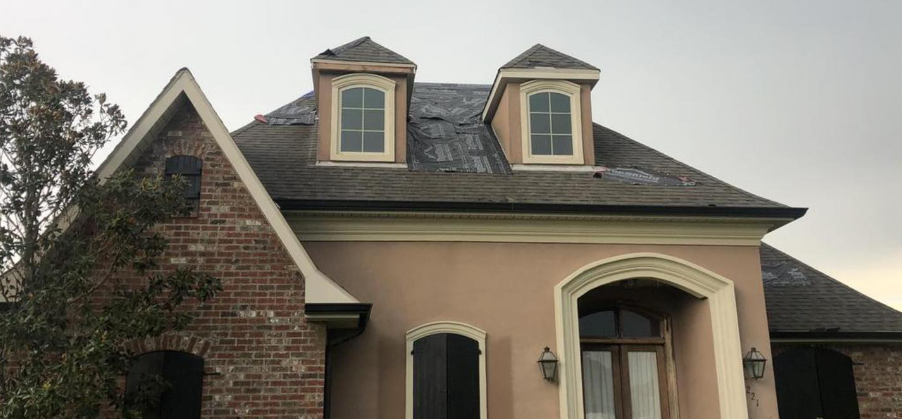 A large brick house with a roof that is covered in shingles.