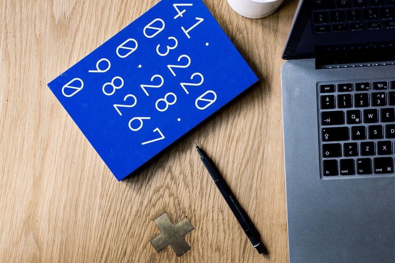 Blue Calculator with black pen on wooden table - Brown Glassford and Co - Farming Accountants Christchurch