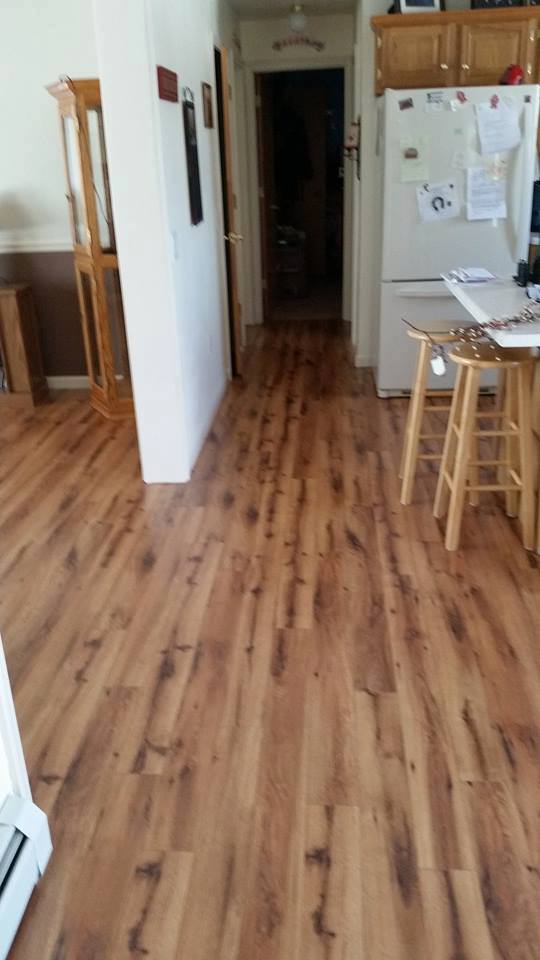 A kitchen with hardwood floors and a refrigerator.