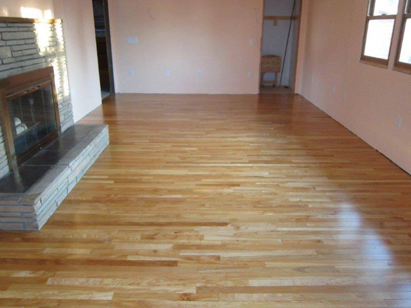A living room with hardwood floors and a fireplace