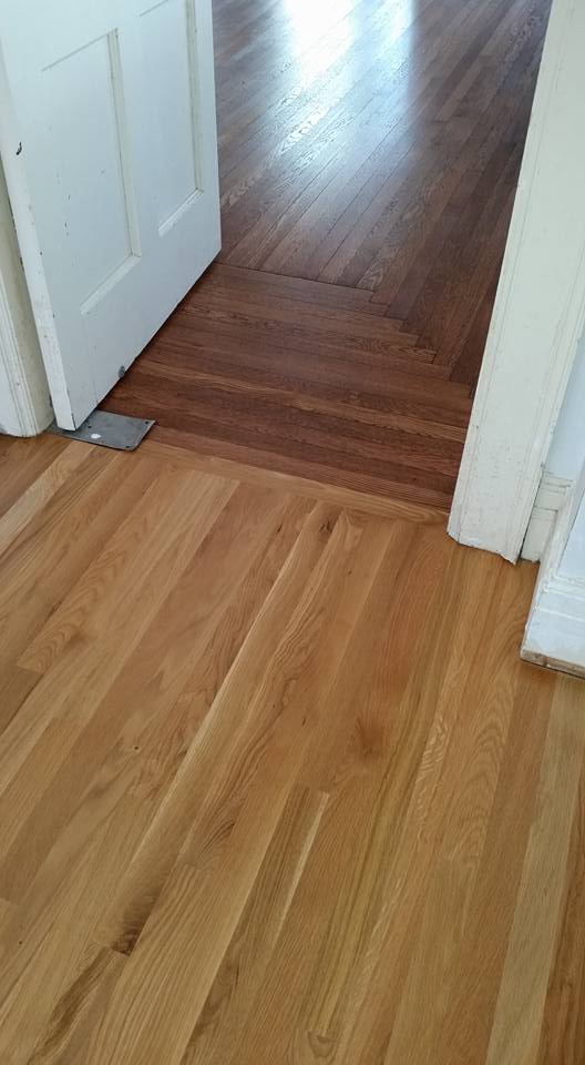 A wooden floor next to a door in a room.