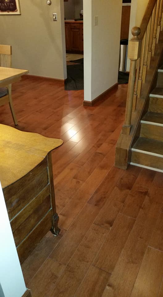A living room with hardwood floors and stairs leading up to the second floor.
