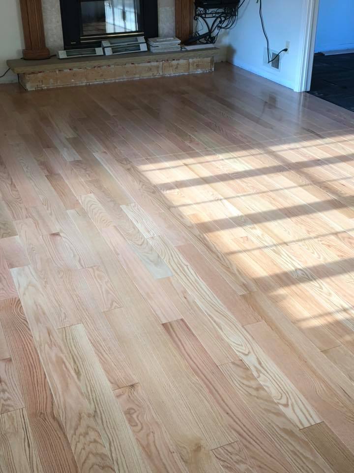 A living room with hardwood floors and a fireplace.