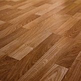 A close up of a wooden floor with a diagonal pattern.