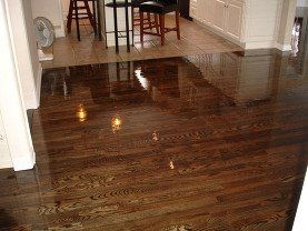 A wooden floor in a kitchen with stools and a table.
