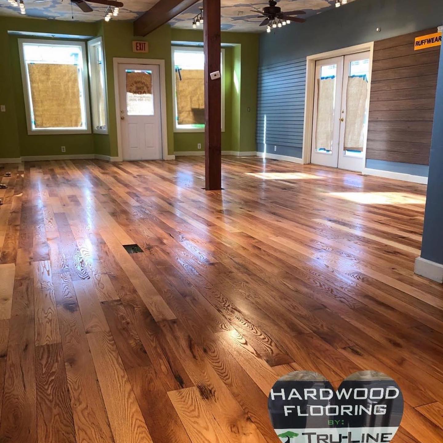 A large room with hardwood flooring by truline