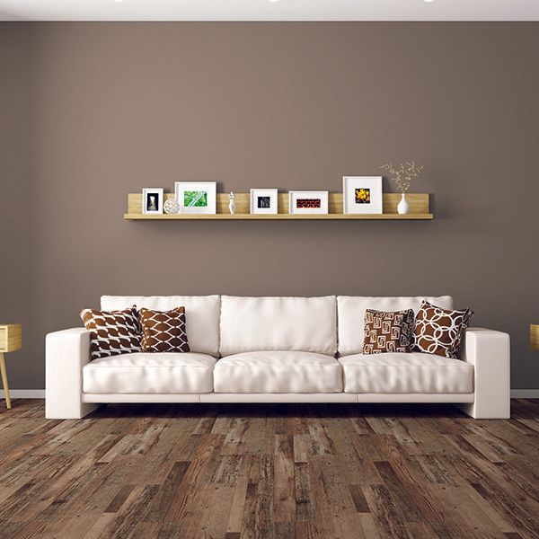 A living room with a white couch and a wooden floor.